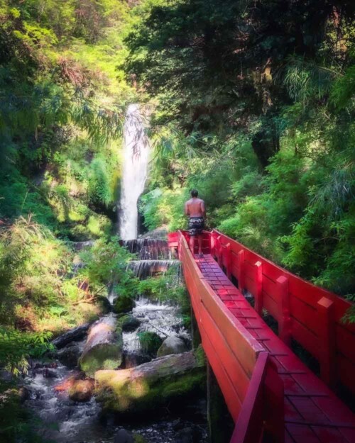 Piscoandbier walking red boardwalk to waterfall at lush Termas Geometricas hot springs