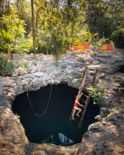 Climbing down Cenote Calavera ladder to the Temple of Doom in Tulum